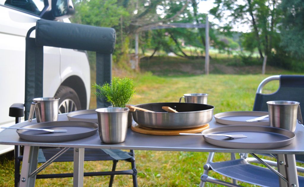 Camper van parked by the river with full equipment.
